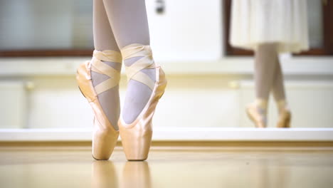 Ballerina-Dancing-Shoes-Close-Up-On-Wooden-Floor-With-Mirror-Behind-In-Slow-Motion