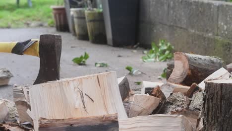 chopping some wood for the fire with a sharp axe at home in the back yard garden shot in slow motion