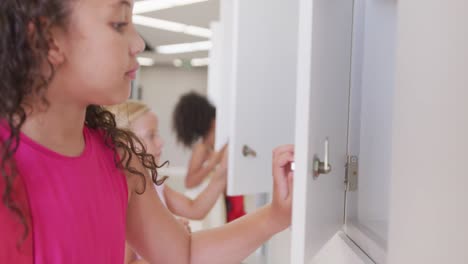 Video-of-happy-diverse-girls-opening-school-lockers