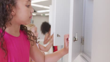 video of happy diverse girls opening school lockers