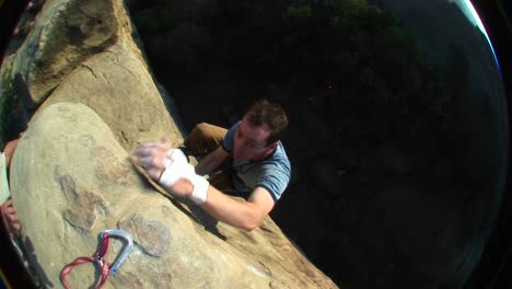 fisheye shot of a rock climber climbing up cliff face