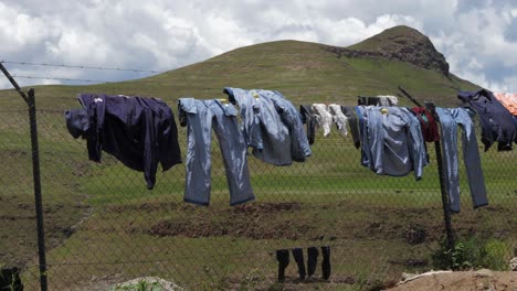 Clothes-drying-on-chain-link-fence-in-Lesotho-highlands-working-camp