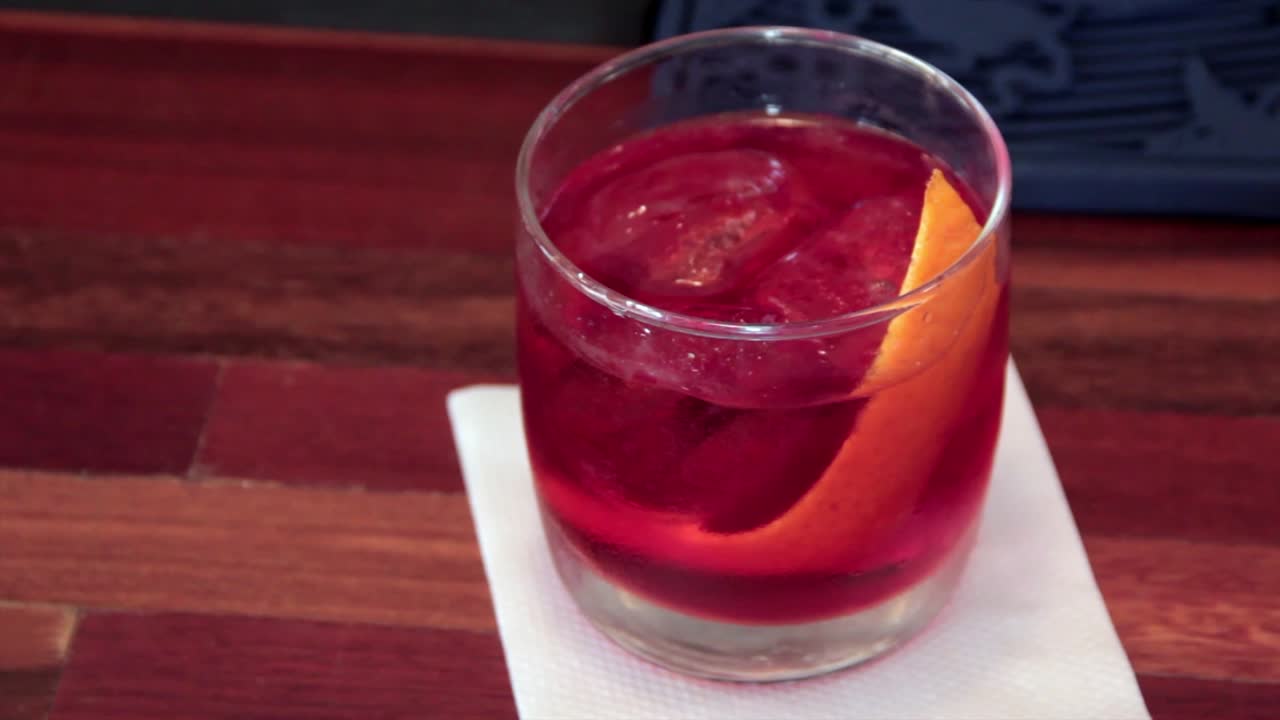 Cocktail Negroni Classico servito in un bicchiere freddo con buccia d'arancia come guarnizione