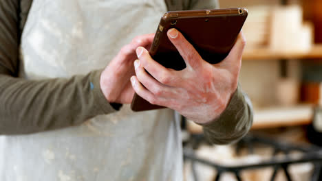 potter using a digital tablet in workshop 4k