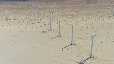 toma aérea en órbita del parque eólico en el desierto de palm springs | iluminación de la tarde