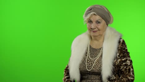 elderly stylish grandmother. caucasian woman pointing at something with hand