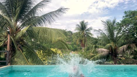 Male-Tourist-Jumps-Into-Infinity-Pool-At-A-Resort-In-Koh-Tao,-Thailand---static-shot