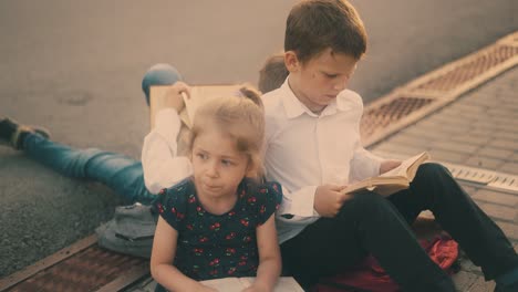 young naughty girl talks to brothers reading books close