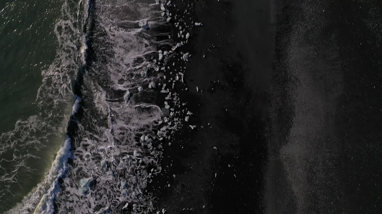 Små isstykker skyllet i land ved Diamond Beach på Sydisland - Rejsemål - droneoptagelse fra luften
