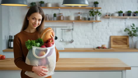young woman with reusable grocery bag in a modern kitchen