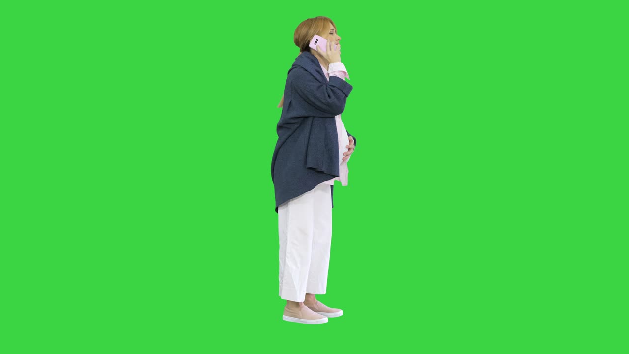 Pregnant woman with contractions feeling pain calling ambulance with cell phone on a Green Screen, Chroma Key