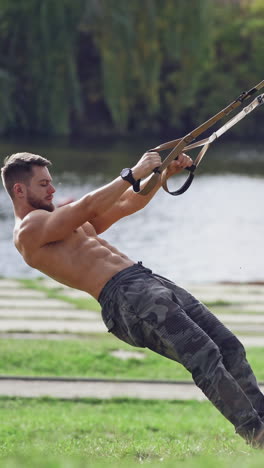 fitness man doing push ups workout. handsome muscular man training outdoor. vertical video