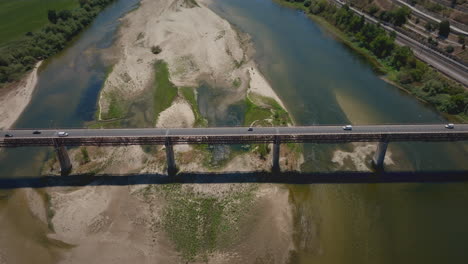 Dry-river-in-summer-over-a-bridge-close-aerial-shot