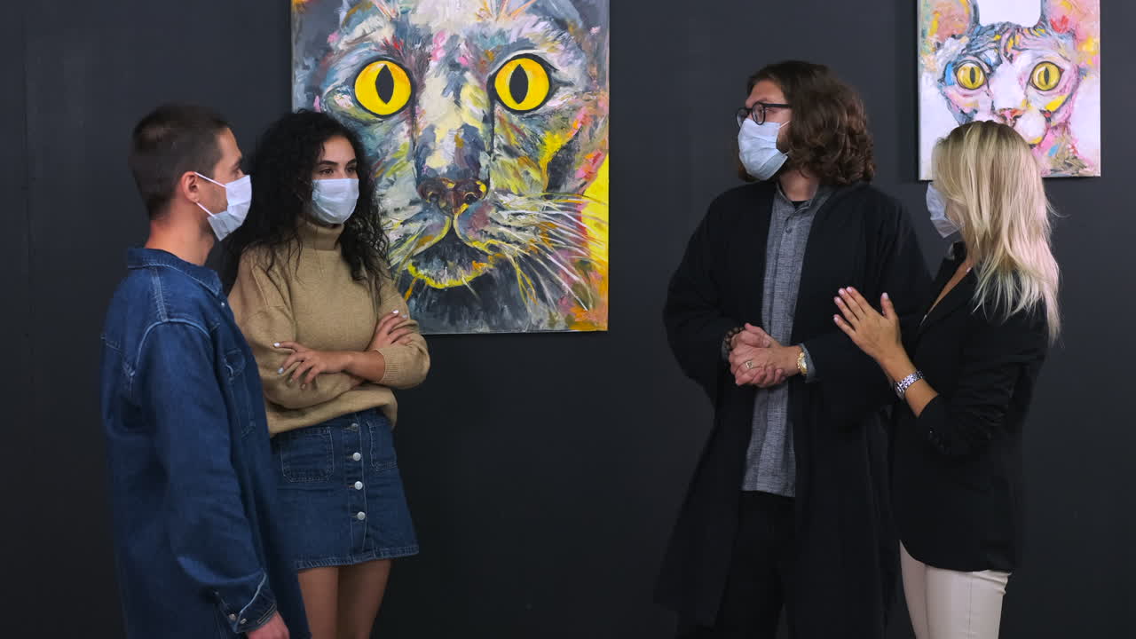 los visitantes de la galería de arte observan la pintura de gatos