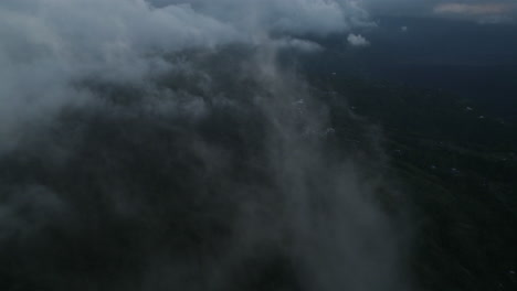 drone dolley tilt shot through white cirrus clouds above mount batur in bali