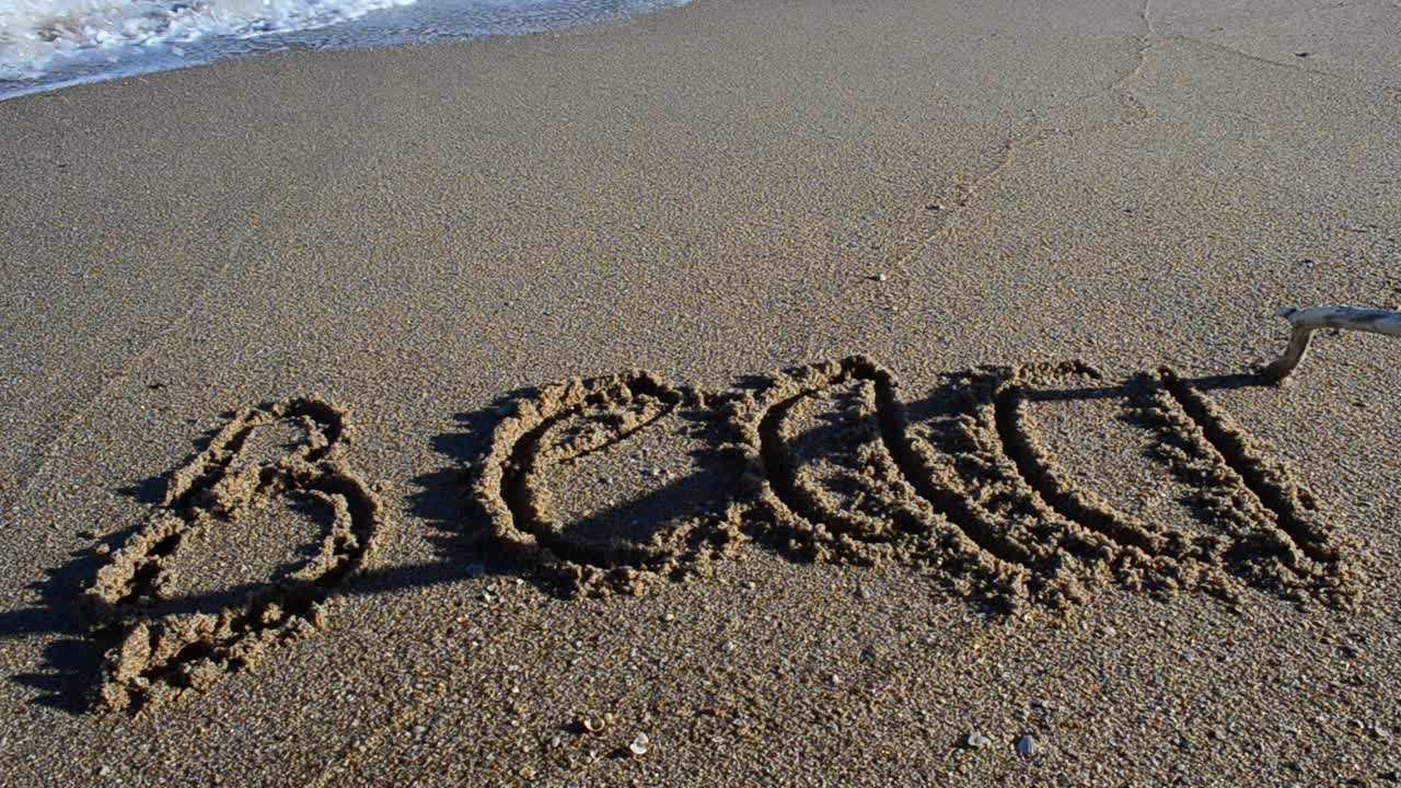 Ordet 'strand' i sandet. Strand. Optagelse på stranden.