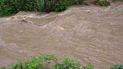 Schmutziger-Fluss-Mit-Schlammigem-Wasser-Nach-Starken-Regenfällen-Verursacht-Überschwemmungen-Und-Starke-Strömung