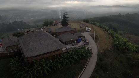 Reveal-shot-of-the-viewpoint-and-mountain-during-sunrise-with-fog-and-smoke-around-the-city