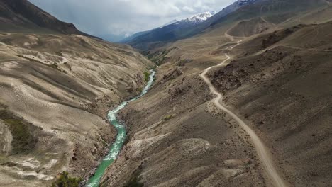 drone aerial landscape fly wakhan valley, secluded mountain road in an earthy solitary natural environment