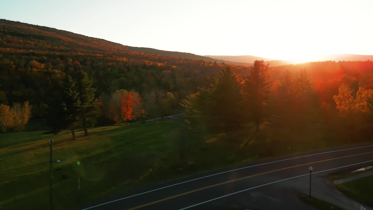 destello de luz de la puesta de sol mientras el dron vuela sobre la carretera - catskills, norte del estado de nueva york