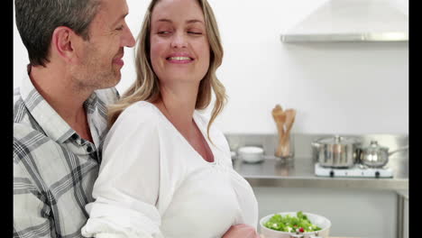 mujer embarazada haciendo una ensalada con su marido