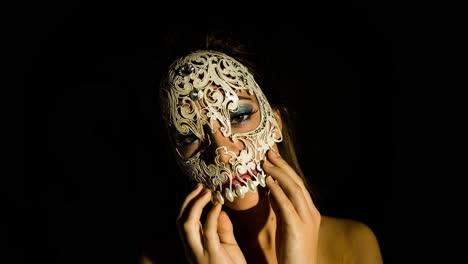 a woman with ornate venetian skull mask over face