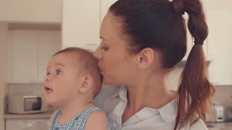 Mother-holding-her-baby-in-the-kitchen