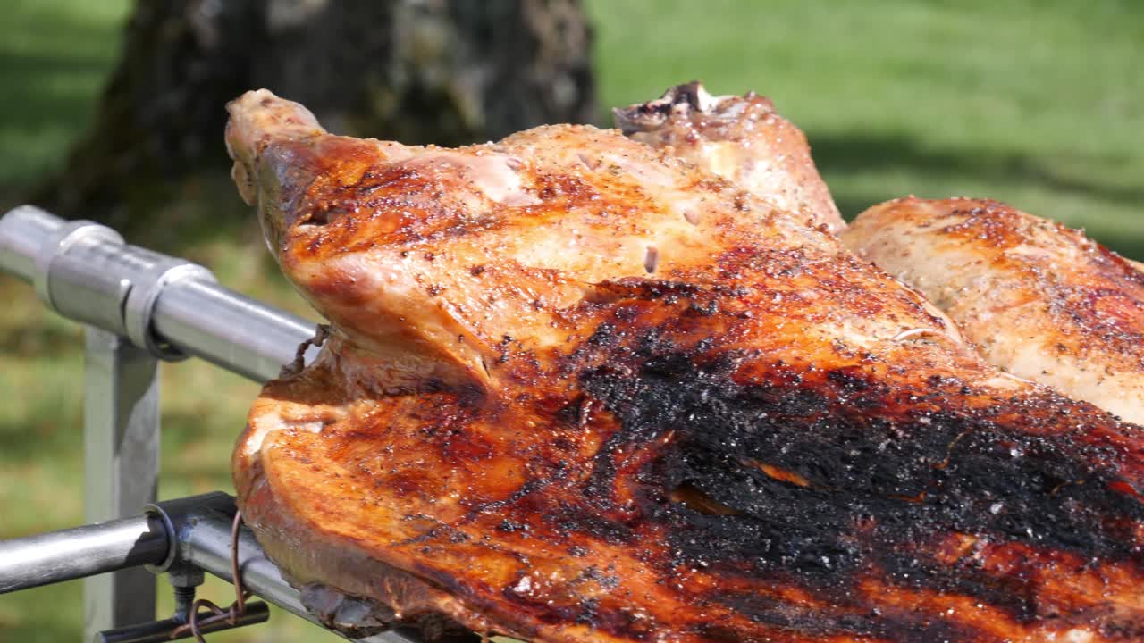 Lamb roasting over coals at an outdorr event such as a wedding or anniversary party