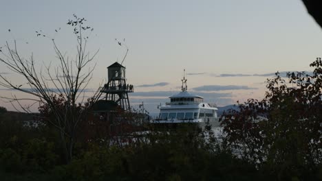 tour boat with people on observation tower on a pier during dusk in magog, quebec, canada