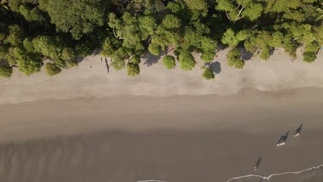 Turistas-Haciendo-Un-Tranquilo-Paseo-A-Caballo-Por-Una-Hermosa-Playa-Durante-La-Puesta-De-Sol-En-Costa-Rica