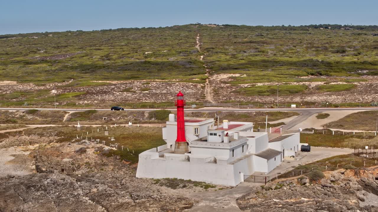 Lighthouse stands on rocky shore in Portugal during sunny weather