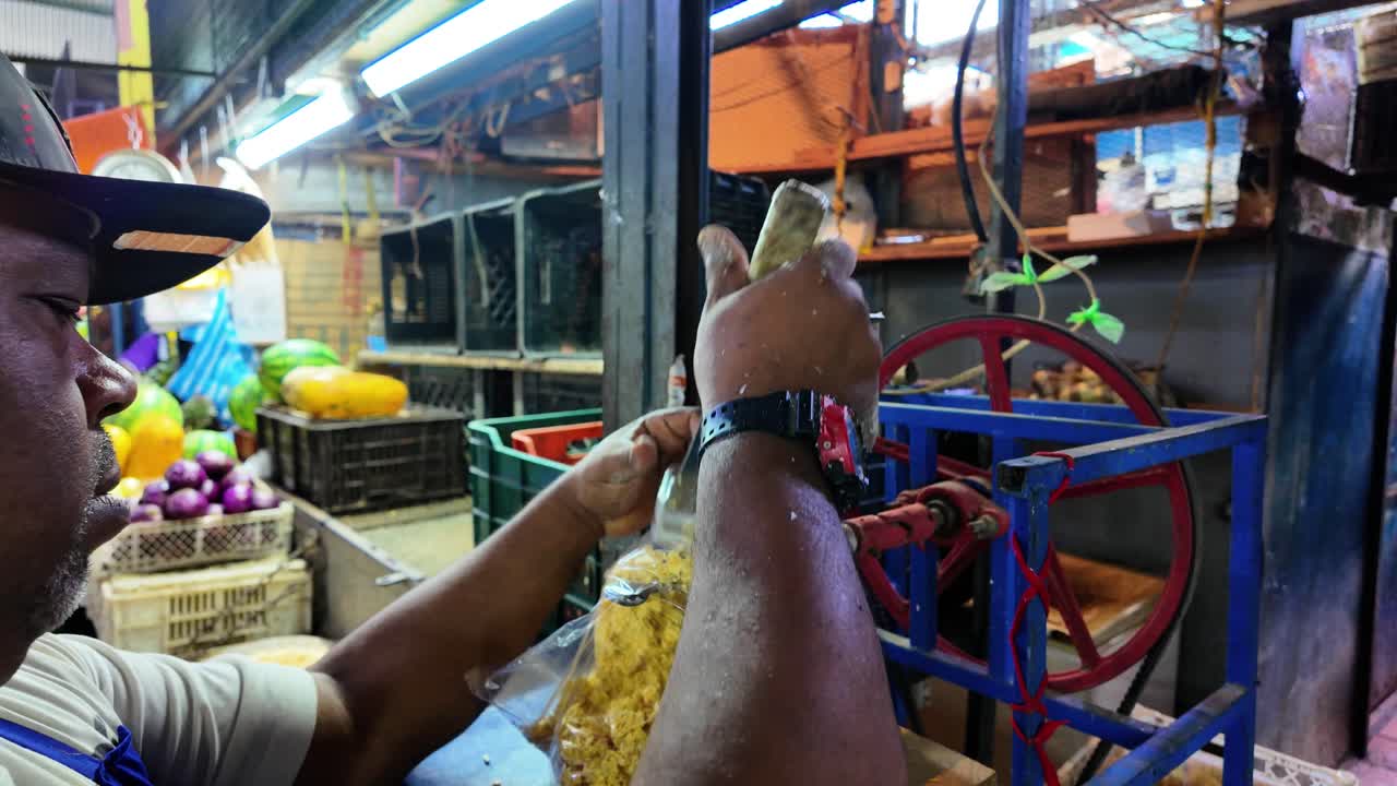 Man grind corn, filling a plastic bag with the processed kernels for cachapas and others traditional meals in Latin America. Food Preparation Market setting