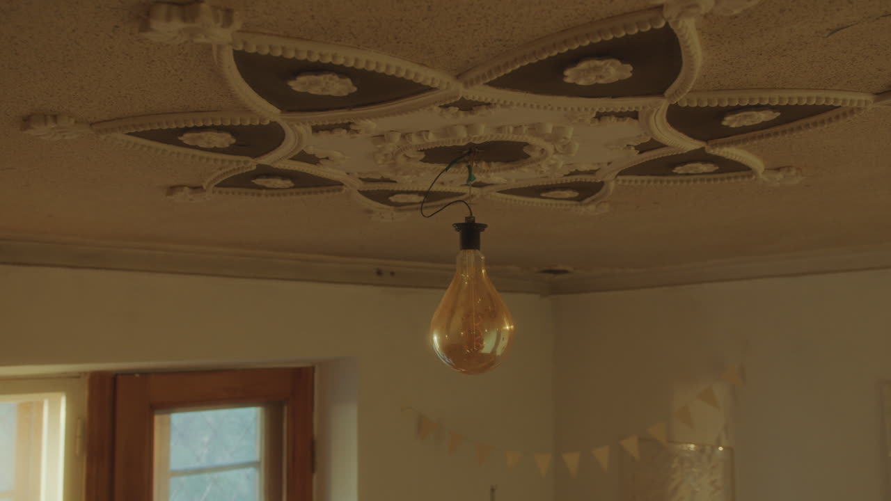 장식 된 천장 에서 매달린 전구 는 방 을 밝히고 조명 한다