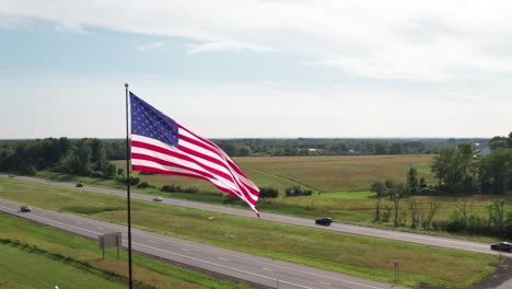 beautiful us flag with highway traffic in the background