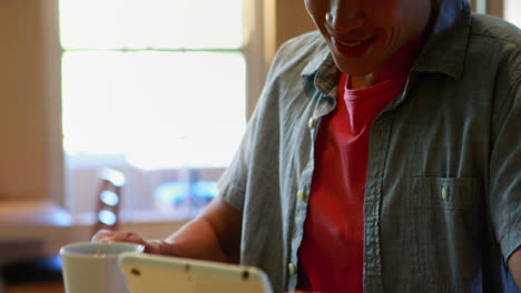 Man-using-digital-tablet-while-having-coffee-in-restaurant-4k