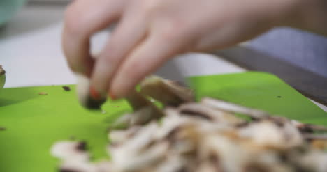 Housewife-Slicing-Mushrooms-In-The-Kitchen-For-Cooking