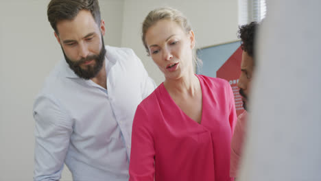 Diverse-male-and-female-business-colleagues-discussing-at-meeting-in-office