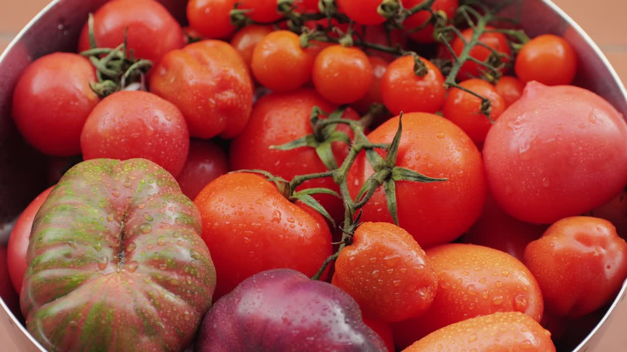 Colorful organic tomatoes. Mix tomatoes background, Several varieties of sliced tomatoes top view. Different assorted colorful tomatoes, heirloom, cherry, rose, beefsteak, cocktail, grape, purple.