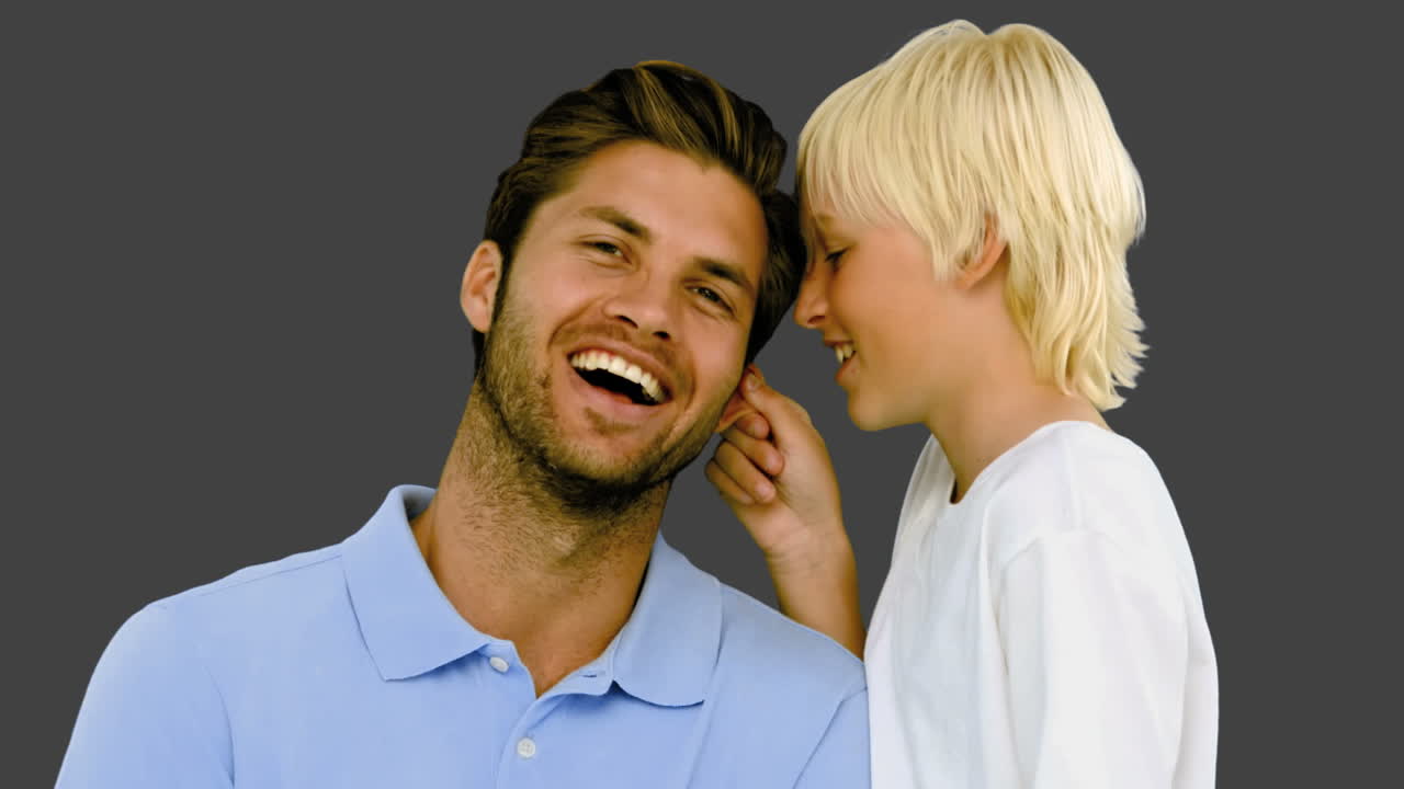 Son pinching the ear of his father on grey background