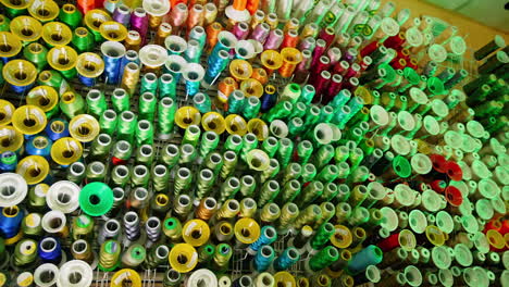 Colorful sewing tools on a wall. Rolls of threads hanging on a wall.