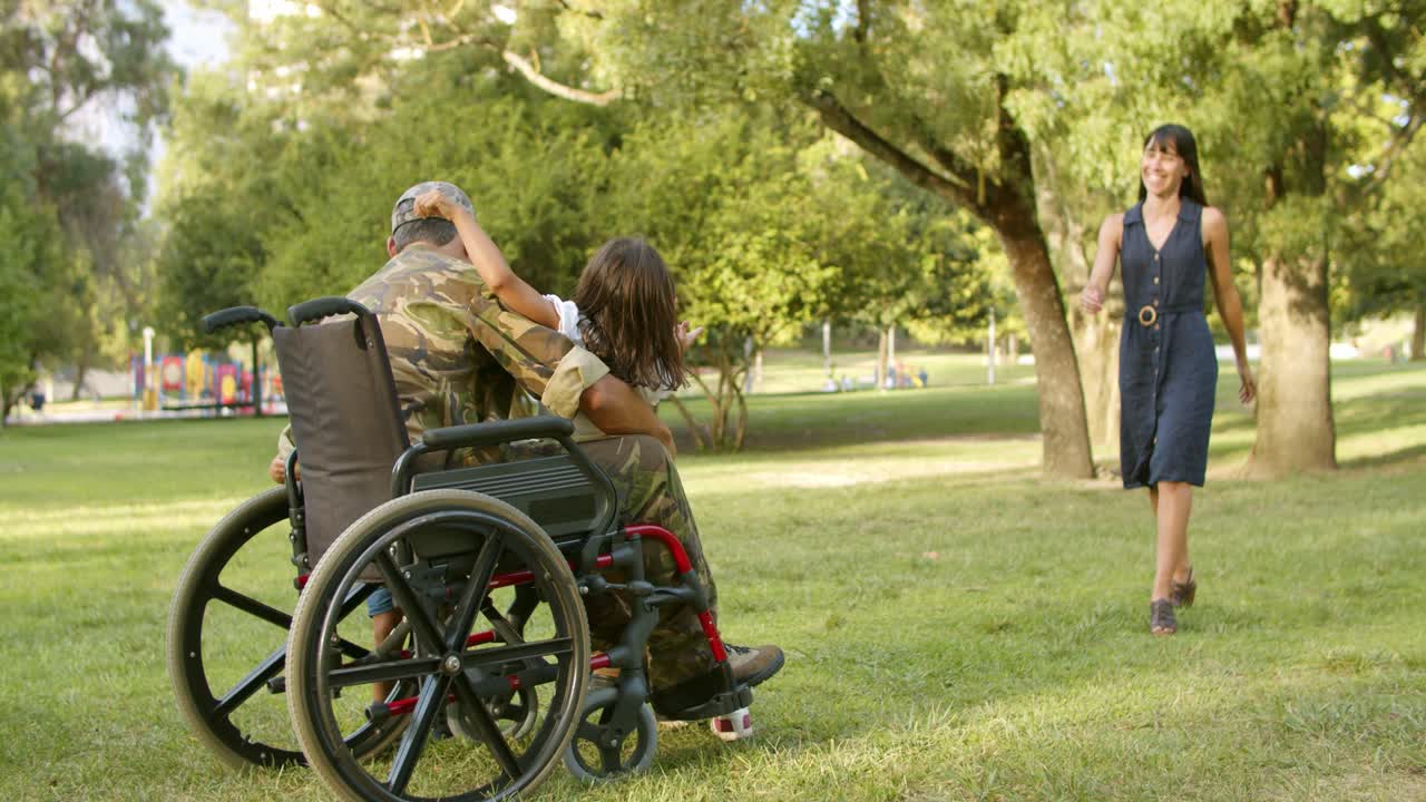 흥분한 아이들과 그들의 엄마는 장애인 군인 아빠에게 달려갑니다.
