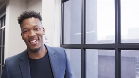 portrait of happy african american male creative at casual office, with copy space, in slow motion