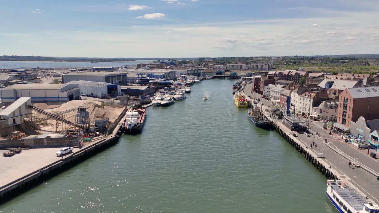 16Flight over working docks and Town Quay , Poole over water towards lifting bridge showing boats moored for loading,boat yard and Town Quay on bright day