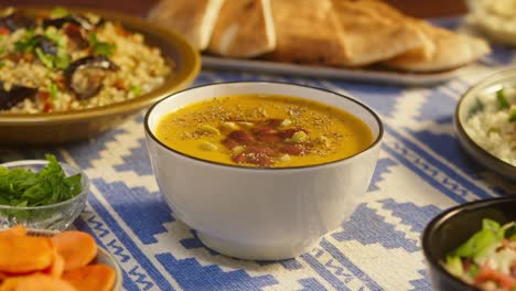 sprinkling spices on bean soup on table close-up. arabian cuisine. pita and bulgur, couscous on background. traditional middle eastern culture. delicious rice with meat. homemade food concept