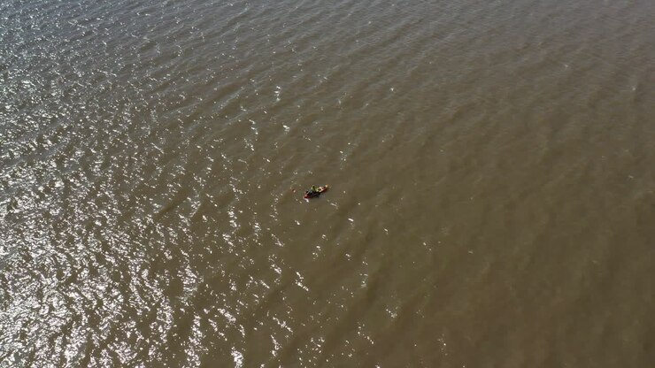 A man in a canoe fishing for food