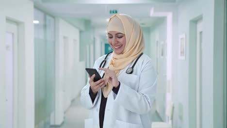 happy muslim doctor using phone