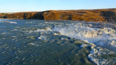 aerial view of frozen urriðafoss waterfall in iceland with wild river