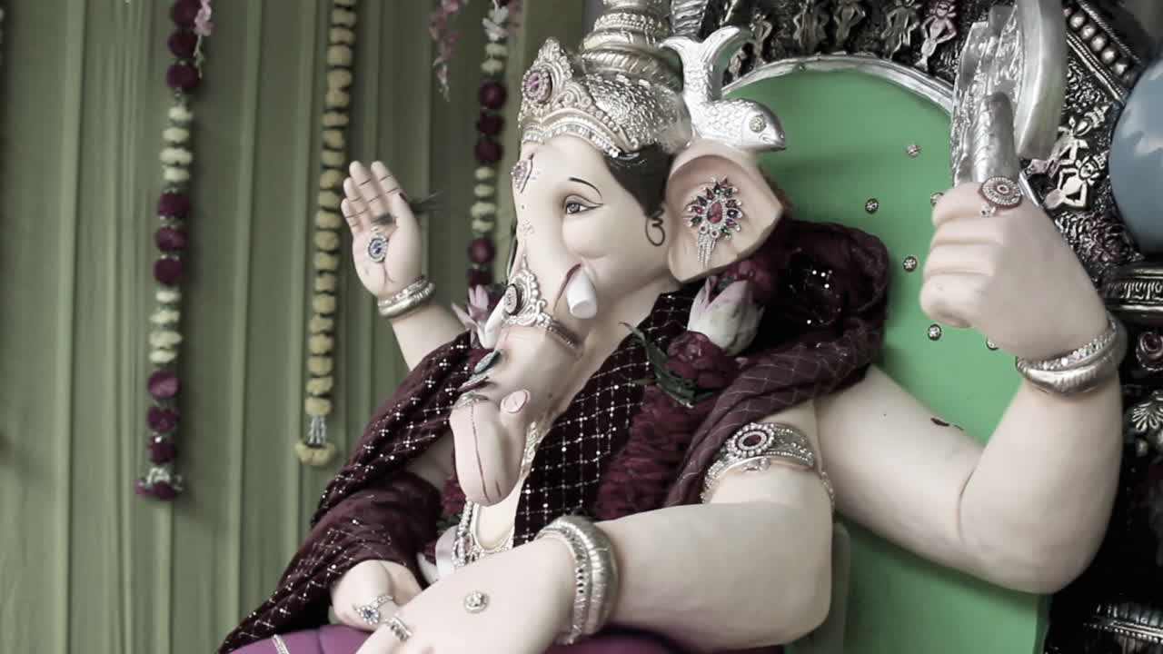 Beautiful Ganpati idol decorated with crown, jewelry and garland for Ganesh Chaturthi festival. Perfect for stock footage on Indian culture, tradition, devotion and spirituality