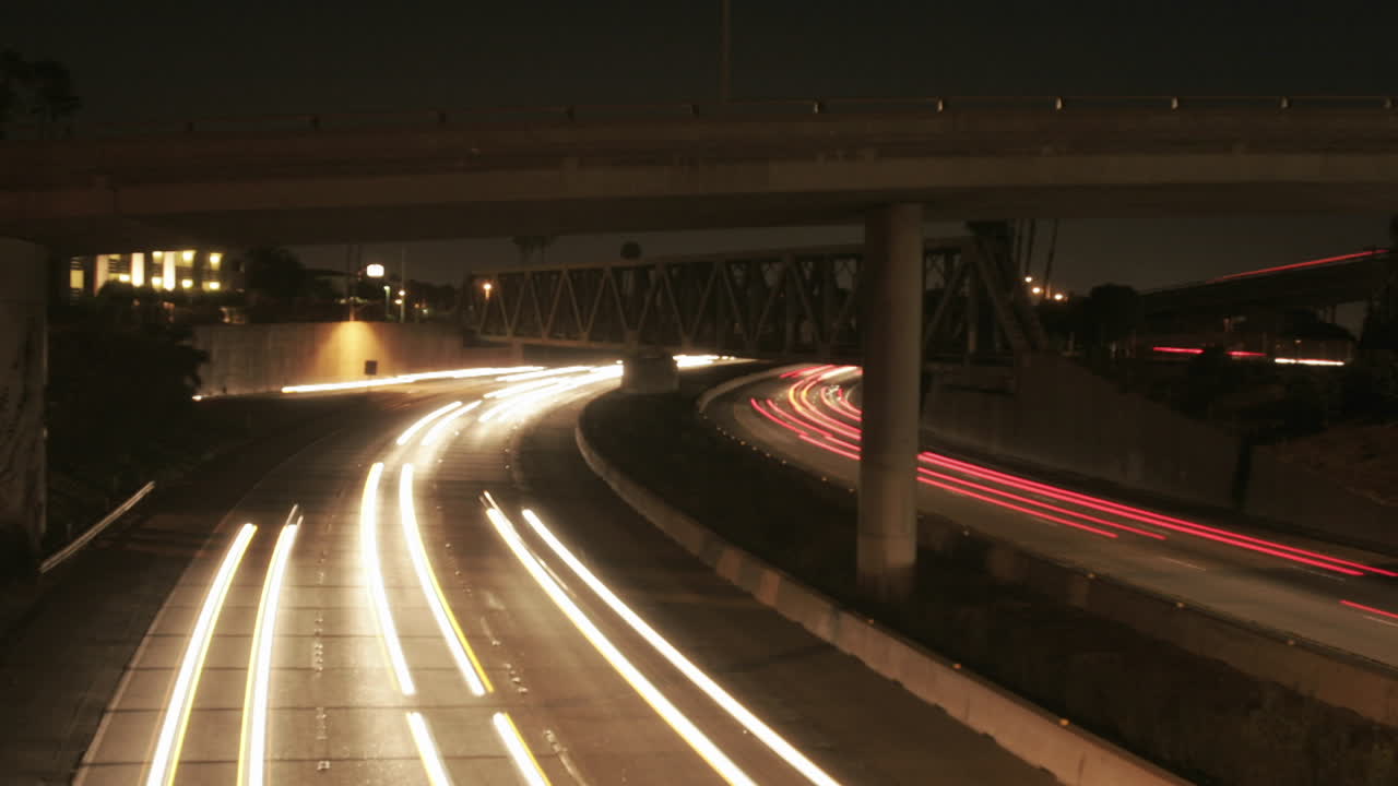 los faros de los vehículos brillan en una autopista por la noche