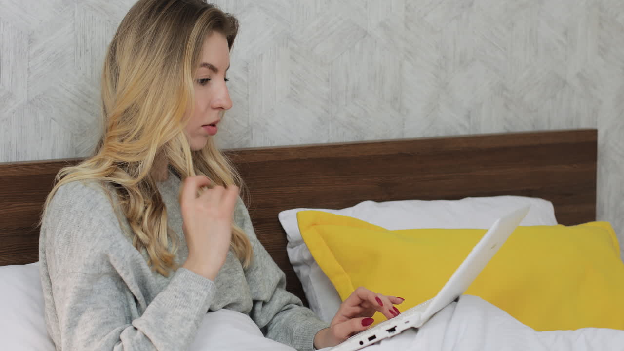 mujer trabajando en la computadora portátil en la cama